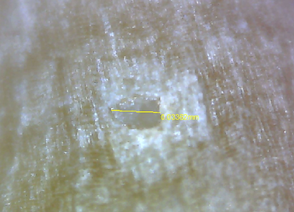 Micrograph of an ablation crater on a seed surface, with the measured width annotated